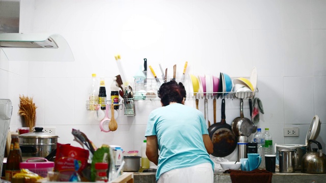 亚洲高级厨师在家做饭时在厨房洗碗，生活理念。视频下载