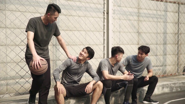 亚洲年轻篮球运动员在球场边放松视频素材