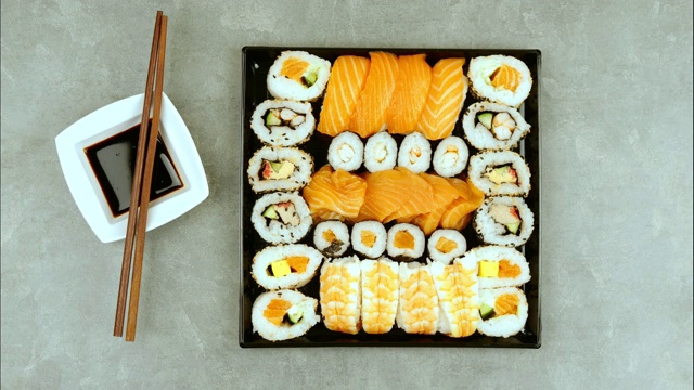日本寿司的食物。寿司和金枪鱼，鲑鱼，虾，螃蟹和鳄梨卷。各式各样的寿司。停止运动视频素材