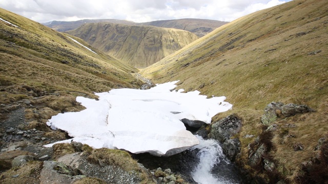 英国湖区Dunmail上方的深谷中漂浮着积雪。视频素材