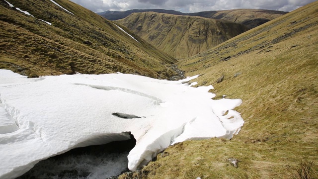 英国湖区Dunmail上方的深谷中漂浮着积雪。视频素材