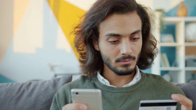 真正的阿拉伯人在网上购物用银行卡和智能手机在家支付视频素材