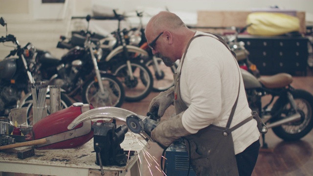 一个成熟的男人在修理厂修摩托车视频素材