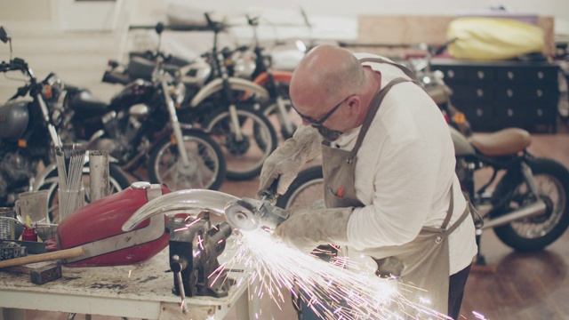 一个成熟的男人在修理厂修摩托车视频下载