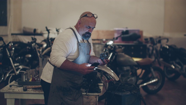 机修工在他的摩托车修理厂工作视频素材