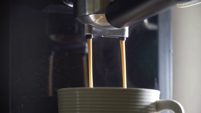 咖啡从机器中倒入玻璃杯视频素材