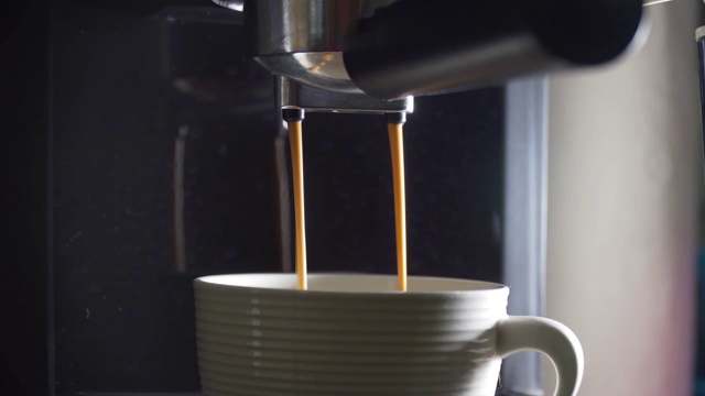 咖啡从机器中倒入玻璃杯视频素材