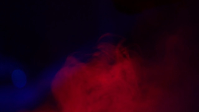 柔和的红色雾在黑暗的背景慢动作。现实大气的红色烟雾在黑色的背景。抽象的烟雾云。烟流效应视频素材