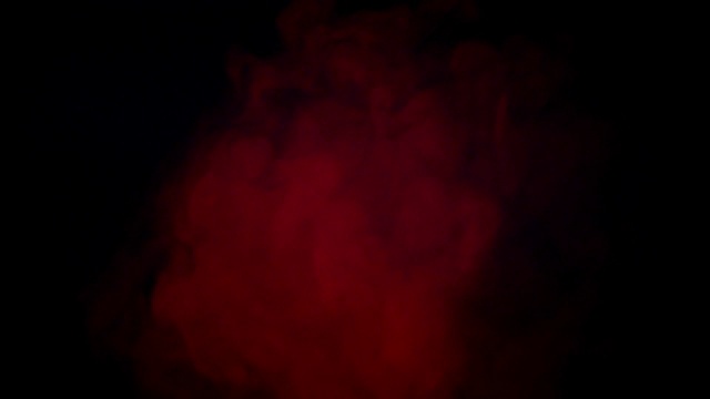 柔和的红色雾在黑暗的背景慢动作。现实大气的红色烟雾在黑色的背景。抽象的烟雾云。烟流效应视频素材