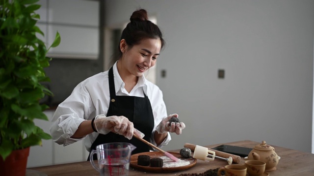 亚洲华人美丽的女人在她的厨房库存照片制作中国传统节雪皮月饼…视频素材