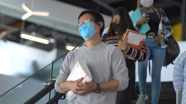 大学生们戴着口罩走楼梯视频素材