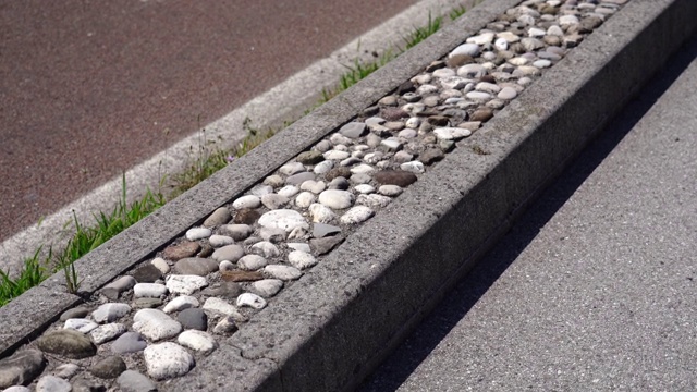 道路和人行道之间用石头和草砌的护栏视频下载