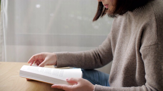 近距离的女人阅读一本书在放松的时间在家里视频素材