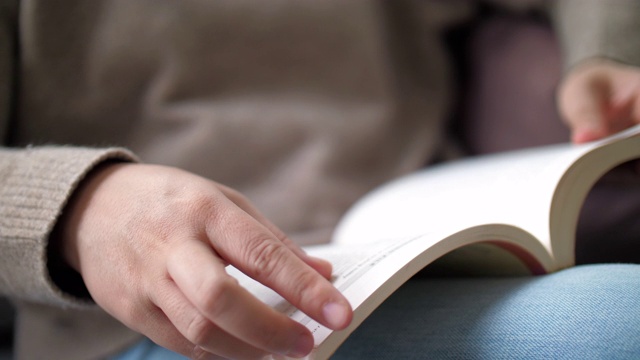 近距离的女人阅读一本书在放松的时间在家里视频素材