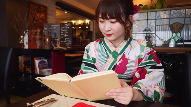 年轻女子在浴田读书在法国餐厅视频下载