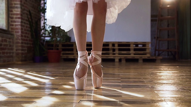 特写的芭蕾舞女演员优雅的脚在芭蕾舞鞋舞蹈芭蕾元素在木地板芭蕾课。在舞厅里跳芭蕾舞的人的脚视频素材