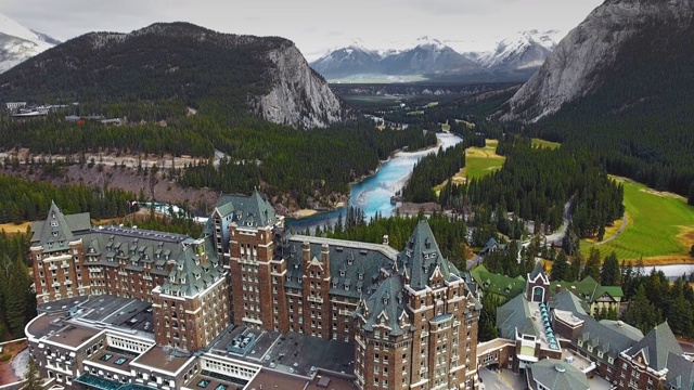 无人机拍摄了加拿大阿尔伯塔省班夫市的一家酒店，该酒店有山脉和森林山谷视频素材