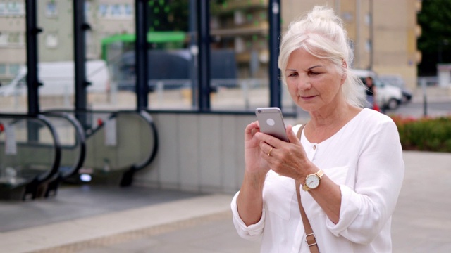 在城市里使用智能手机的资深女性视频素材