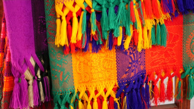 五颜六色的墨西哥羊毛毛毯的质地。编织装饰生动的纺织品与正宗的拉丁美洲图案。用于斗篷和宽边帽的条纹多色织物。西班牙本土风格视频素材