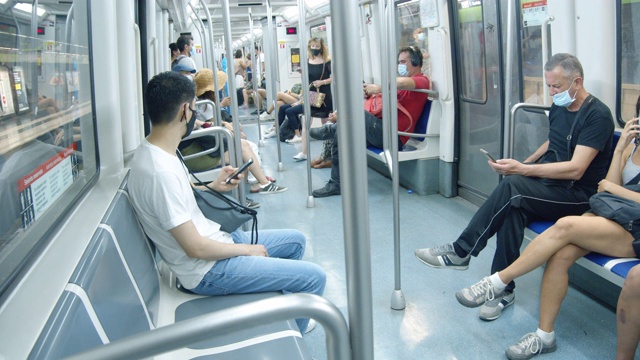 冠状病毒危机期间，巴塞罗那地铁成为新常态。2020年夏季新冠肺炎期间，在列车内部佩戴口罩的人员视频素材