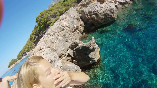克罗地亚亚得里亚海，一对夫妇带着可穿戴相机跳入阳光明媚的海洋中视频下载