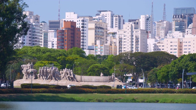 在一个阳光明媚的日子里，巴西圣保罗，Ibirapuera的公园泻湖和城市的背景视频下载