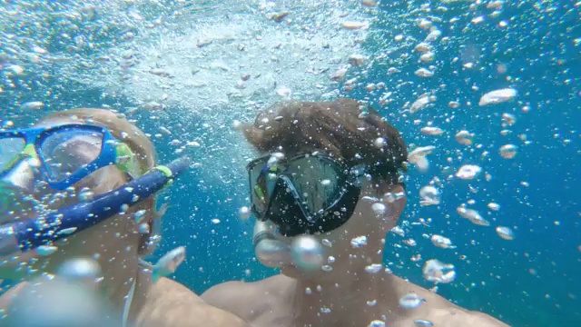 图为一对夫妇在克罗地亚阳光明媚的亚得里亚海水下浮潜视频素材