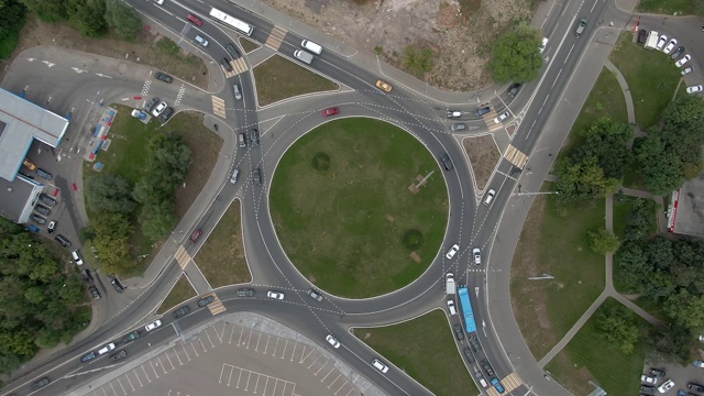 鸟瞰图汽车交通在一个环岛在大城市。自上而下的无人机盘旋飞行视频素材