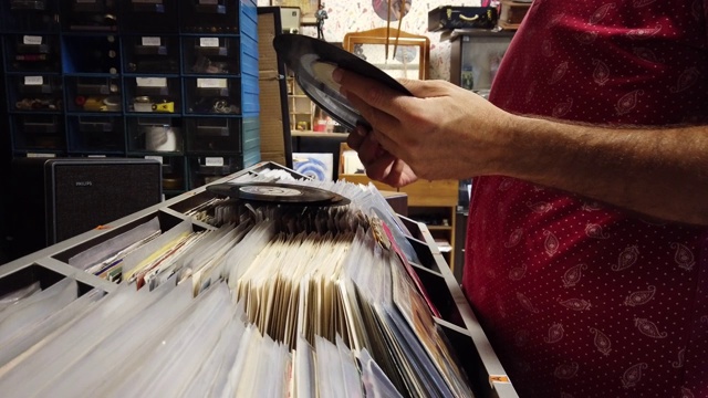 一个年轻人正在唱片店看旧唱片视频素材