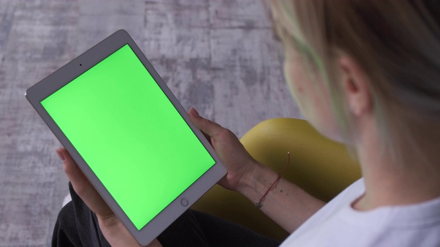 拿着绿色屏幕和色度键的平板电脑的女人。视频素材