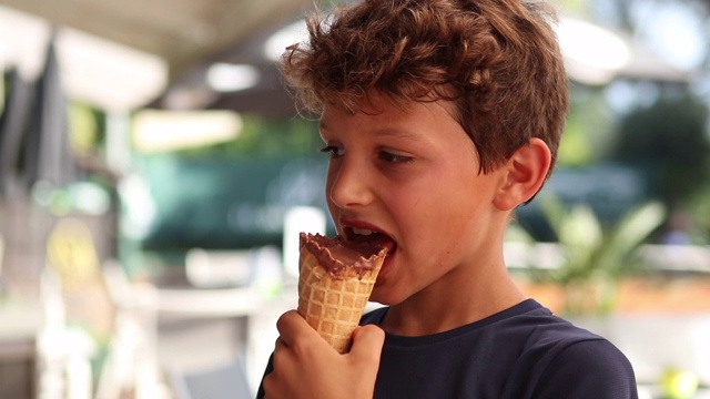 孩子吃冰淇淋。小男孩吃甜点巧克力冰淇淋视频素材