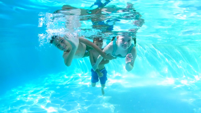 孩子们在水下游泳，患有唐氏综合症的女孩视频素材