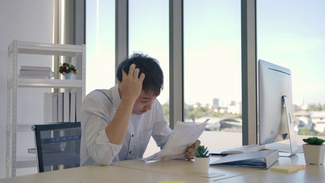 沮丧的商人坐在办公室的电脑显示器前视频素材