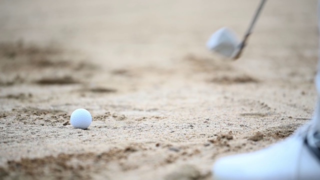一位亚洲的中国资深高尔夫球手用他的铁棒在沙坑里打他的高尔夫球视频素材