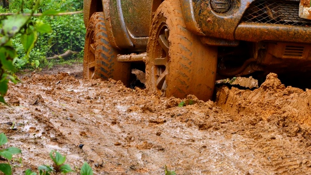 一辆四轮驱动的小货车陷在泥里，正试图爬出泥潭。视频素材