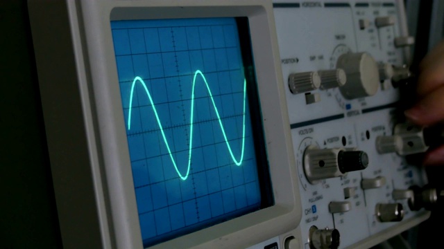 示波器上的振幅图。一个男人按下设备上的按钮。几何线改变形状视频素材