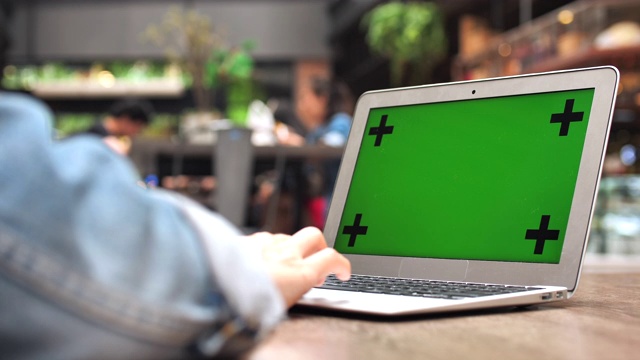 使用绿色屏幕笔记本电脑的女人视频素材