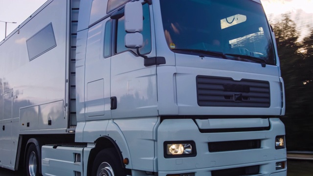 在高速公路上行驶的带有拖车的货运卡车。白色卡车在清晨运送货物视频素材