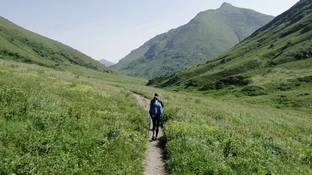一对年轻的旅行者在山里徒步旅行视频下载