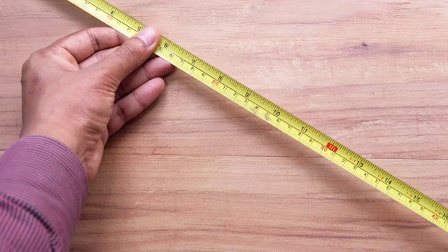 用卷尺测量工具在木头上测量。视频下载