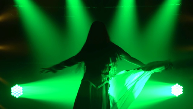 性感的女孩热情跳舞在黑暗的工作室与烟雾和绿色霓虹灯。剪影迷人的黑发在性感的西装在英国国旗的颜色和莱茵石。性感女性舞蹈秀视频下载