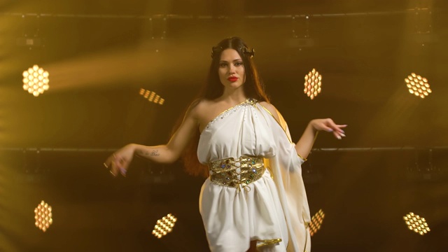 穿着金色希腊服装的女孩在剧院的舞台上跳舞视频素材