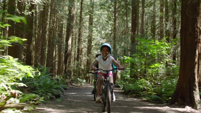 妈妈骑着自行车在森林里与青春期的儿子和女儿视频购买