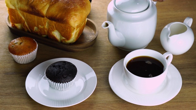 早餐时，将黑咖啡倒入白色陶瓷咖啡杯中。视频下载