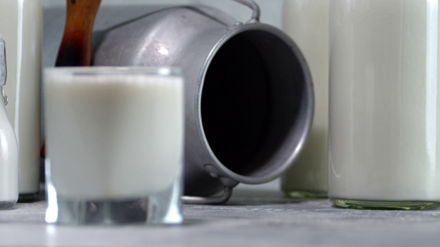 牛奶在玻璃杯里，瓶子在桌子上。视频素材
