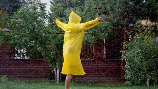 一个上了年纪的女人在花园里旋转，在雨中快乐视频下载