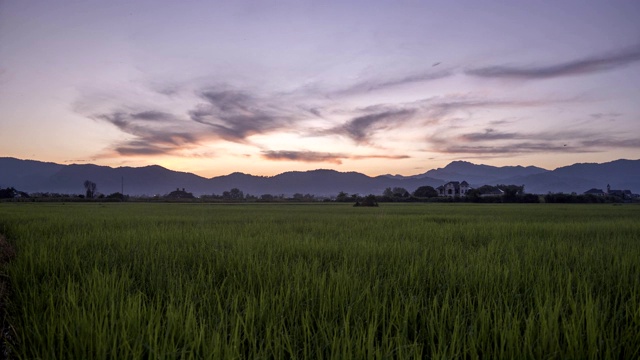 时间流逝4k视频观看稻田和山在日落时间之前天黑。视频素材