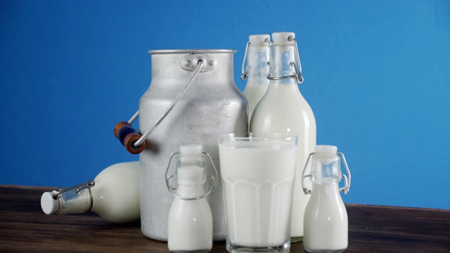 桌上的瓶子、玻璃和罐子里的牛奶慢慢地旋转着。视频下载