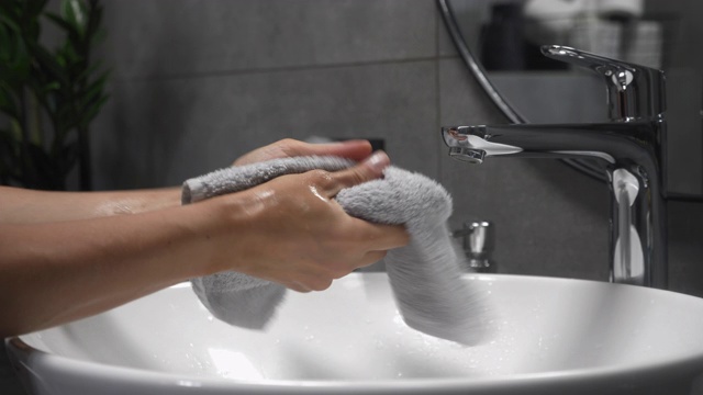 女人在水池里洗手，涂肥皂搓手指。预防冠状病毒大流行。女性在洗涤槽用泡沫洗手，水从手上流过视频下载
