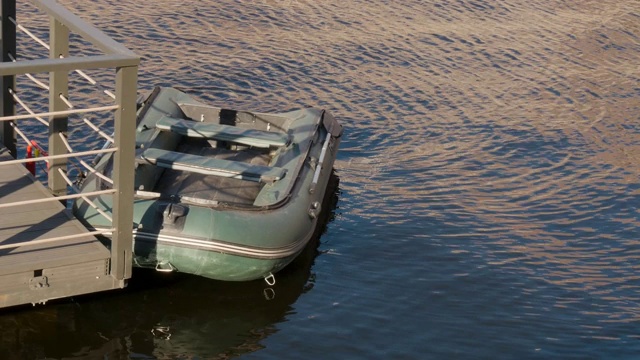 绿色充气船停泊码头。水上的橡皮艇。钓鱼的主题视频素材